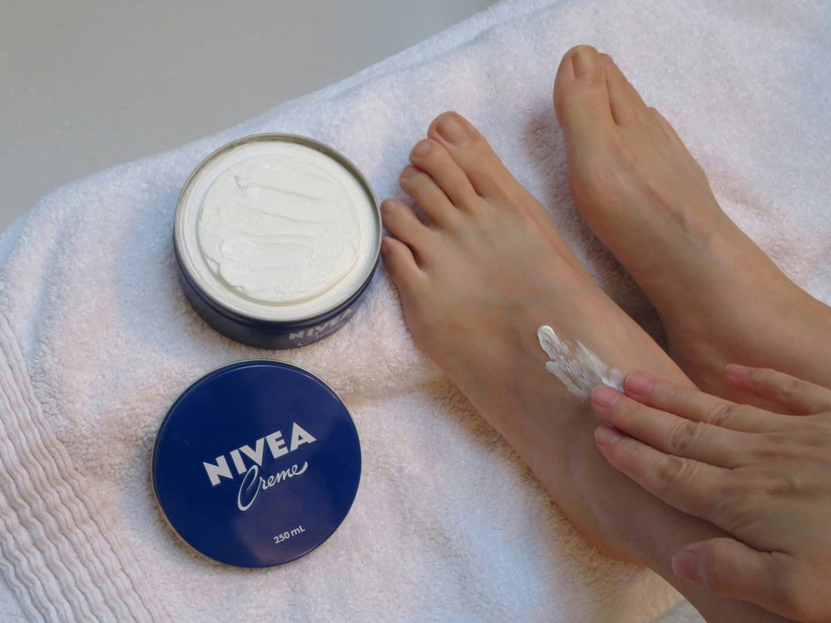 Woman applying foot care cream moisturizer what is to cracked heels before bed