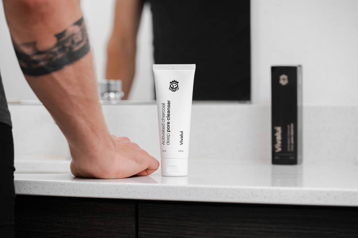 Woman applying dry skin cream for feet to cracked heels while sitting on bathroom floor
